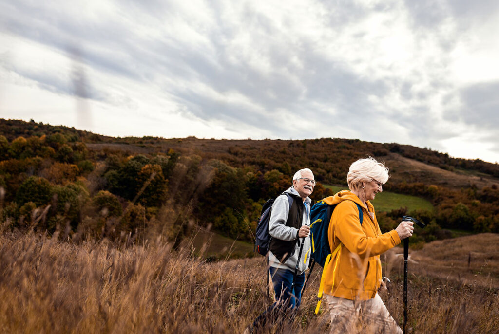 man and woman smiling while hiking