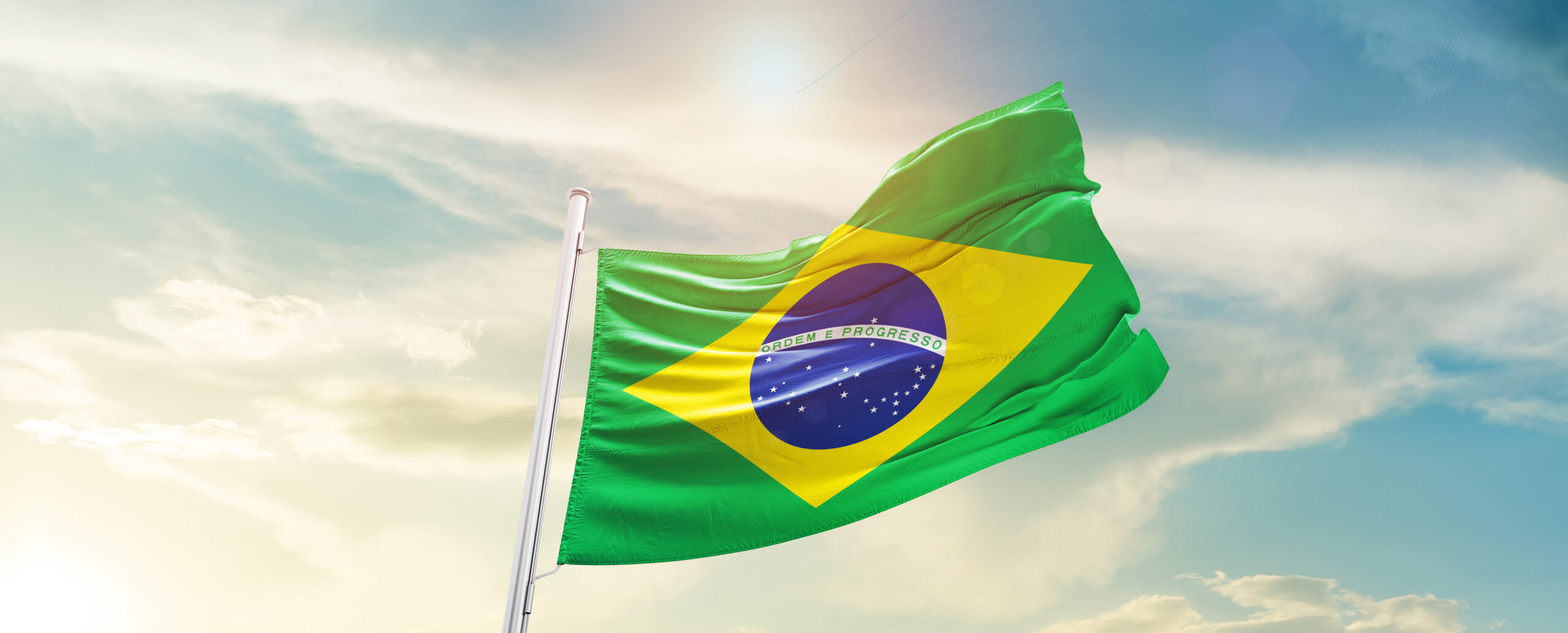 Brazil national flag waving in beautiful sky.