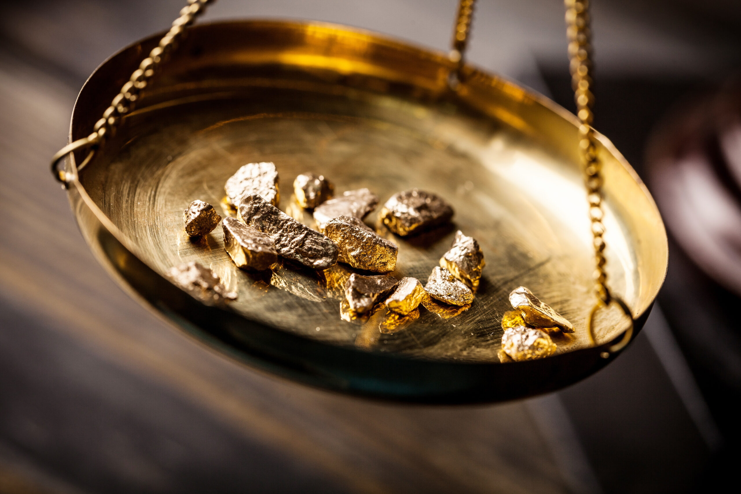 Small gold nuggets in an antique measuring scale